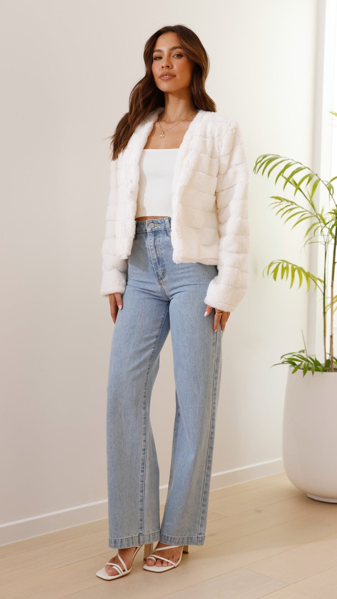 Full length view of woman posing in white cropped jacket