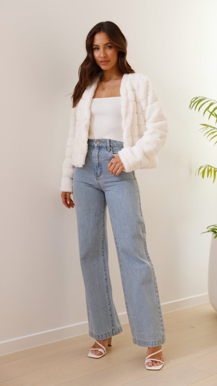 Front view of white textured cropped jacket highlighting premium fabric details