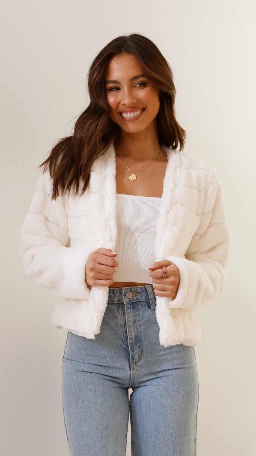 Woman wearing white cropped texture jacket facing front