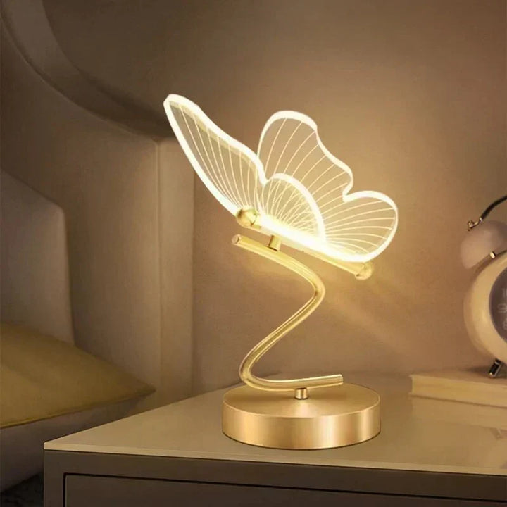 Close up of the modern butterfly LED table lamp glowing warmly on a nightstand