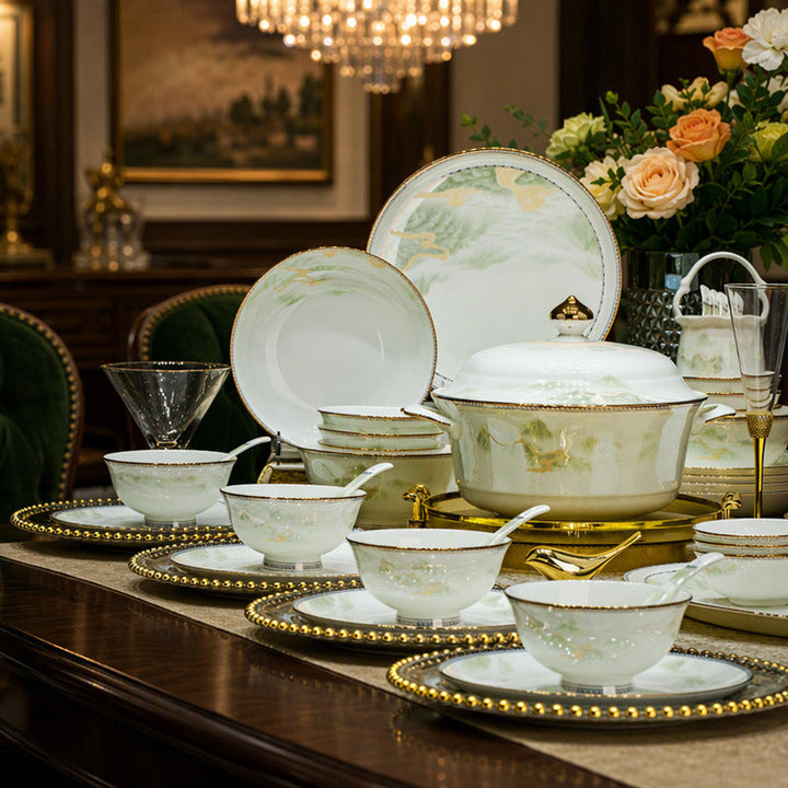 Luxury porcelain dinnerware set with gold rim displayed on a beautifully set dining table