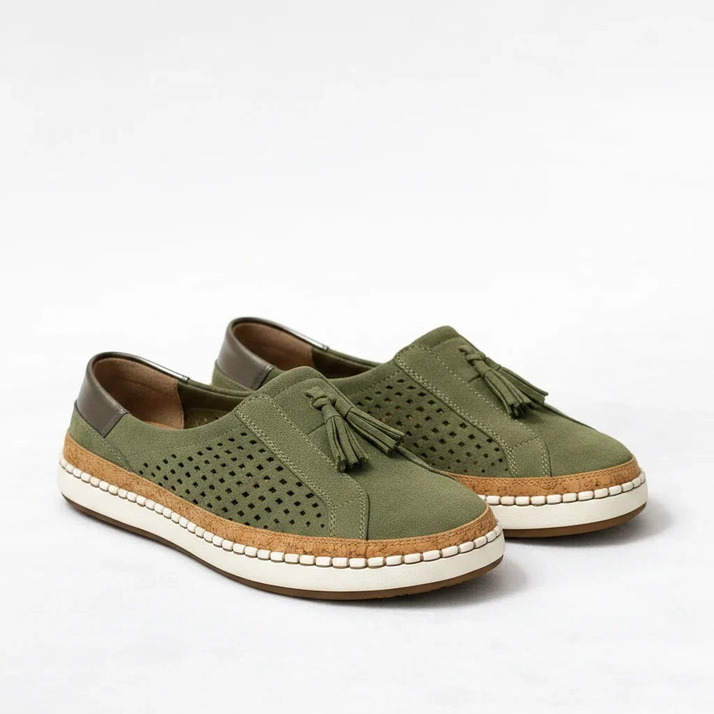Pair of green women's orthotic slip-on sneakers with cork sole and tassel detail