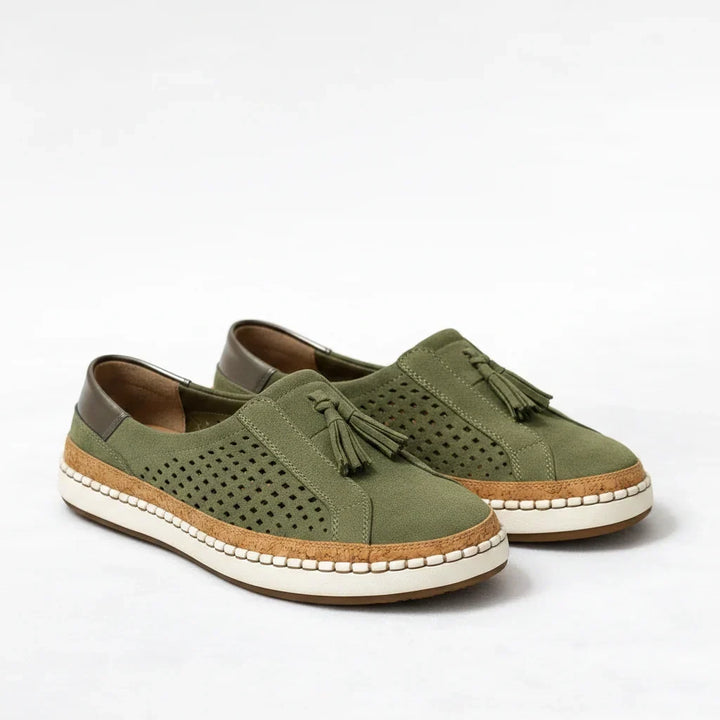 Pair of green women's orthotic slip-on sneakers with cork sole and tassel detail