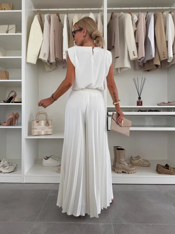 Back view of woman showcasing the flowing silhouette of a white two piece outfit