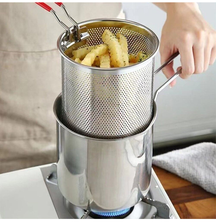 Stainless steel deep fryer with frying basket holding golden fries over a stove
