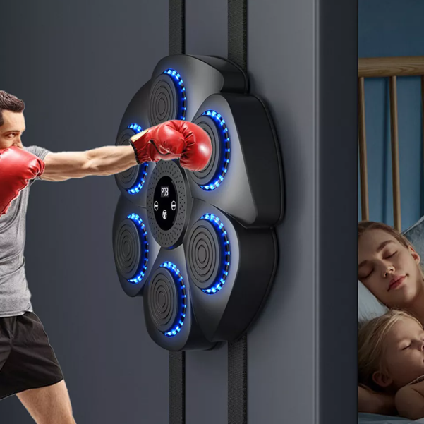Man punching a black wall-mounted musical boxing pad with red gloves