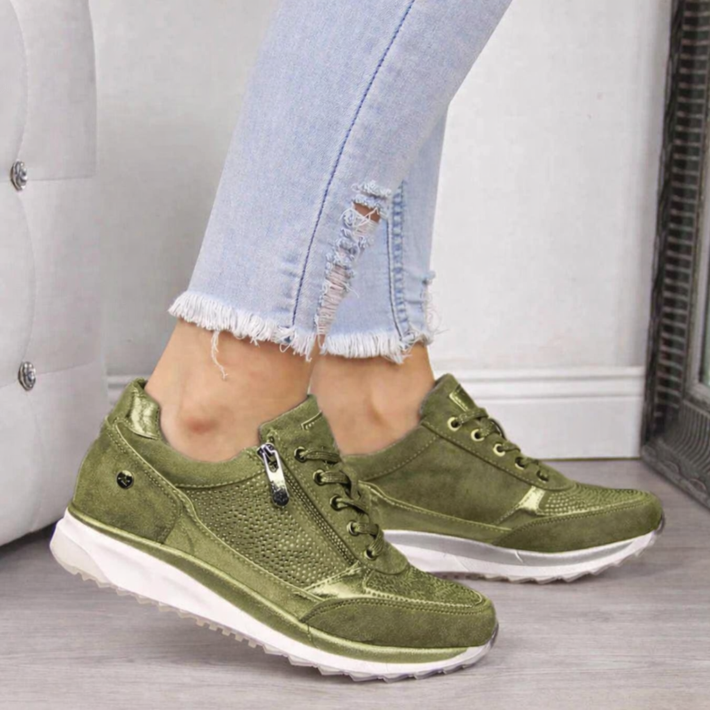Woman wearing green studded orthopedic sneakers with side zip and wedge sole