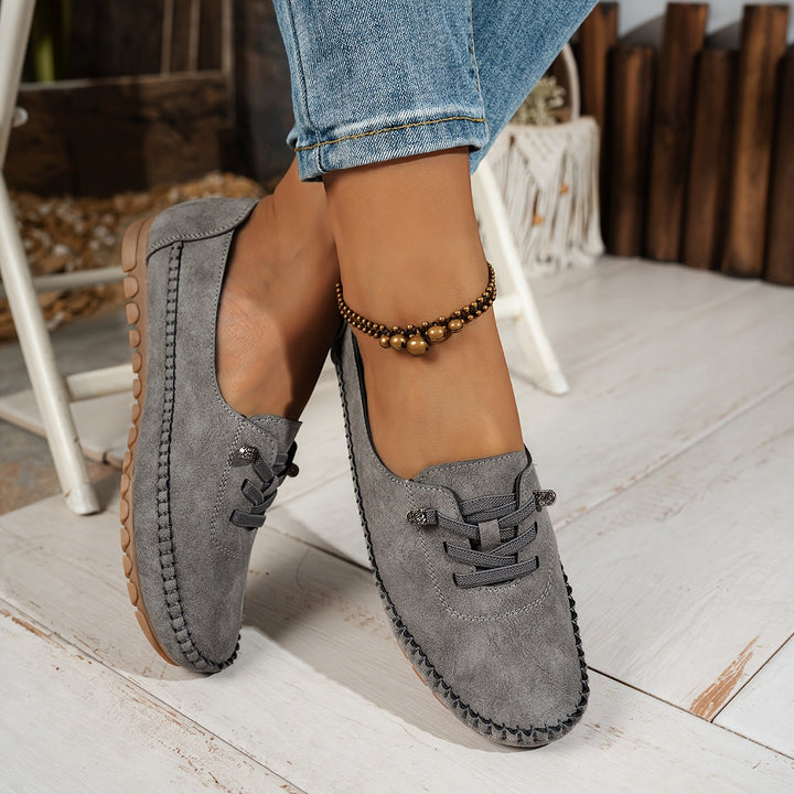 Side angle of grey mesh walking shoes paired with blue jeans
