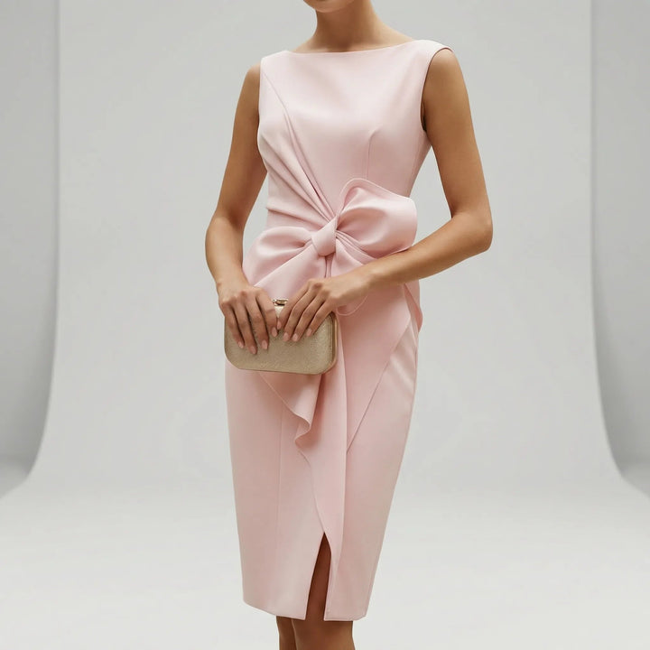 Close-up of the bodice and waist bow detail on the pink midi dress