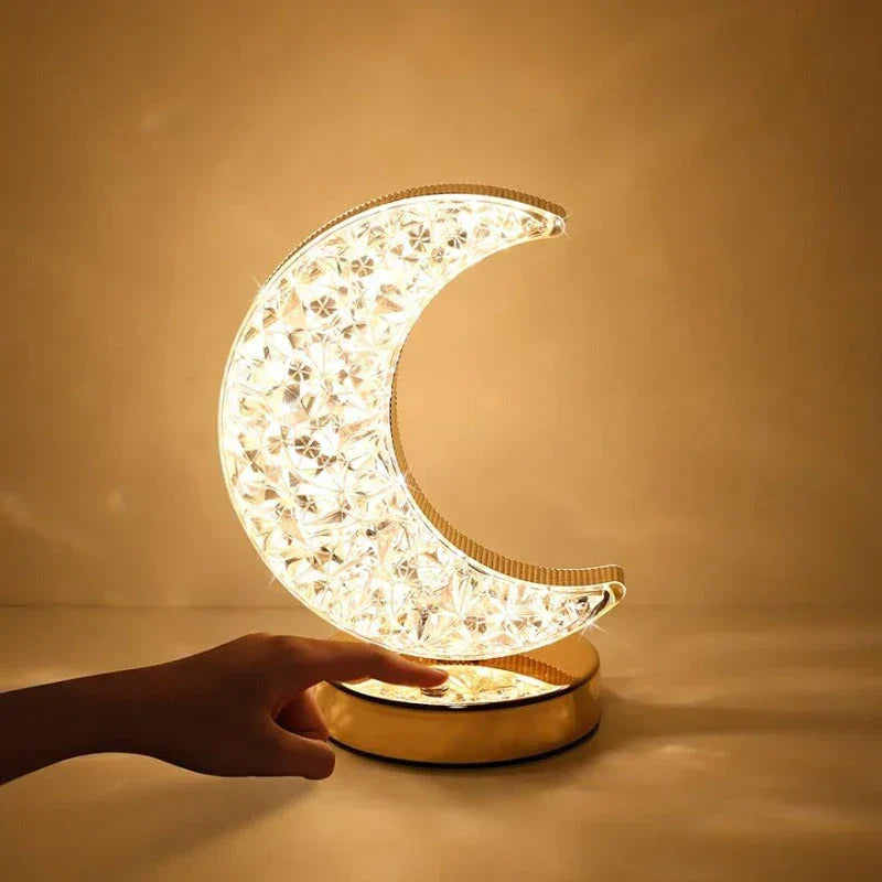 Moon shaped crystal table lamp glowing with warm light