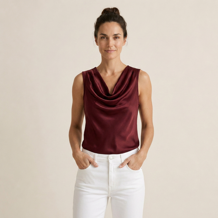 Front view of a model wearing the burgundy sleeveless satin top with cascade neckline