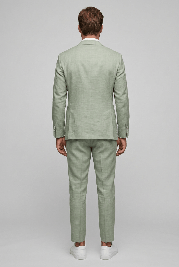 Full-length rear view of a man wearing a green two-piece suit