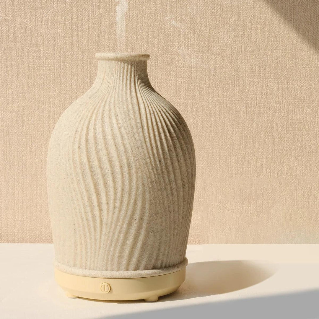 Ultrasonic humidifier operating on a wooden nightstand diffusing scented mist.