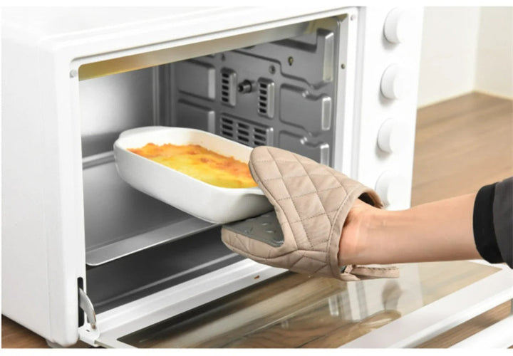 Person using a fish shaped silicone oven glove to remove a baking dish from the oven