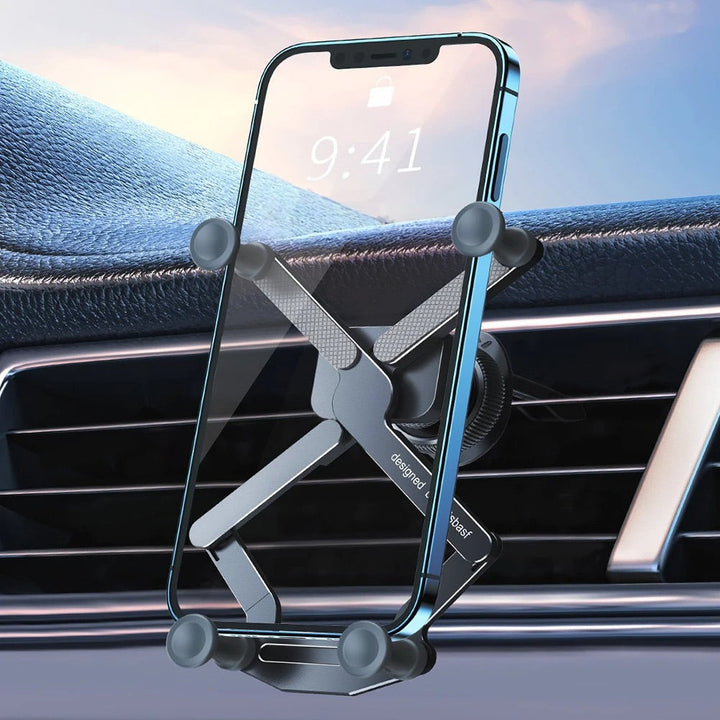 Close-up of a smartphone secured in a metal car phone mount attached to a vehicle air vent