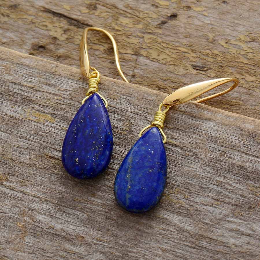 Handcrafted Selene lapis lazuli drop earrings displayed on wood