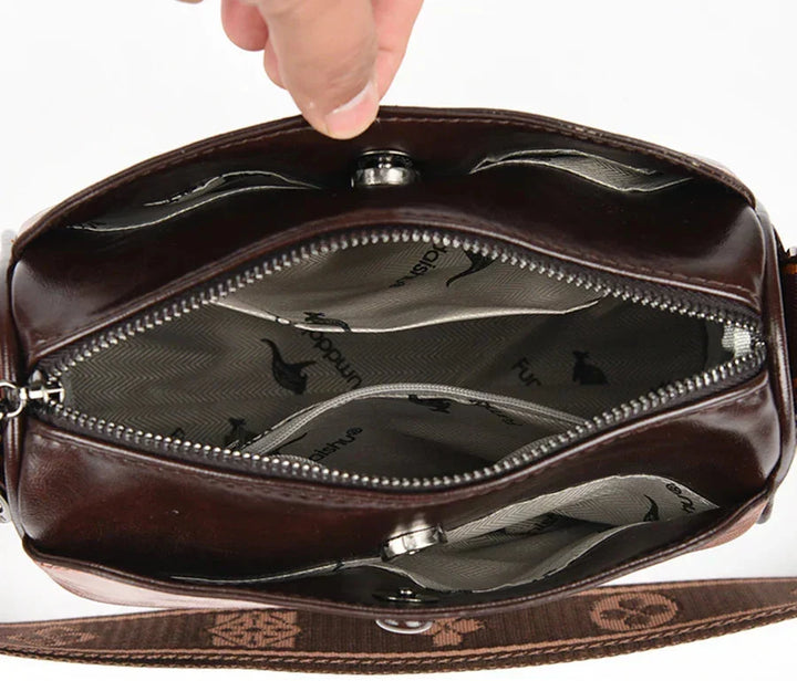 Detailed shot of the secure zipper closure and metallic clasp on the shoulder bag