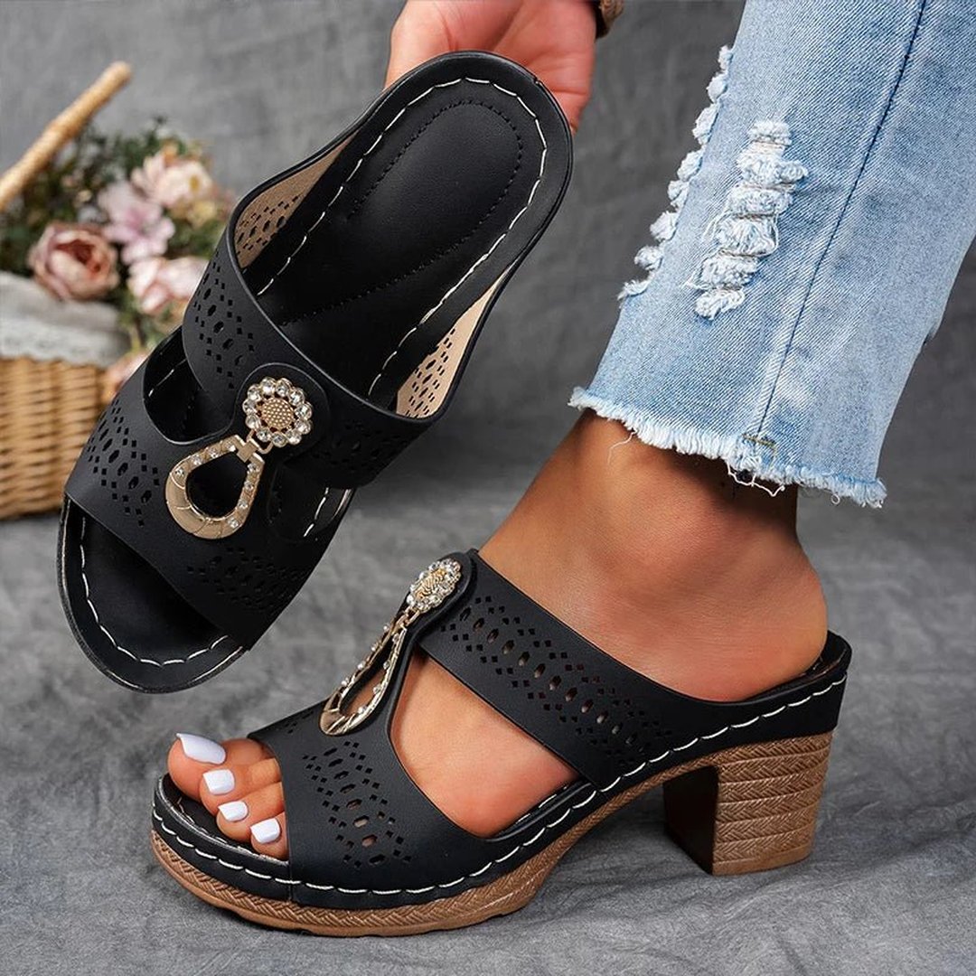 Woman wearing black orthopedic slide sandals with decorative embellishment
