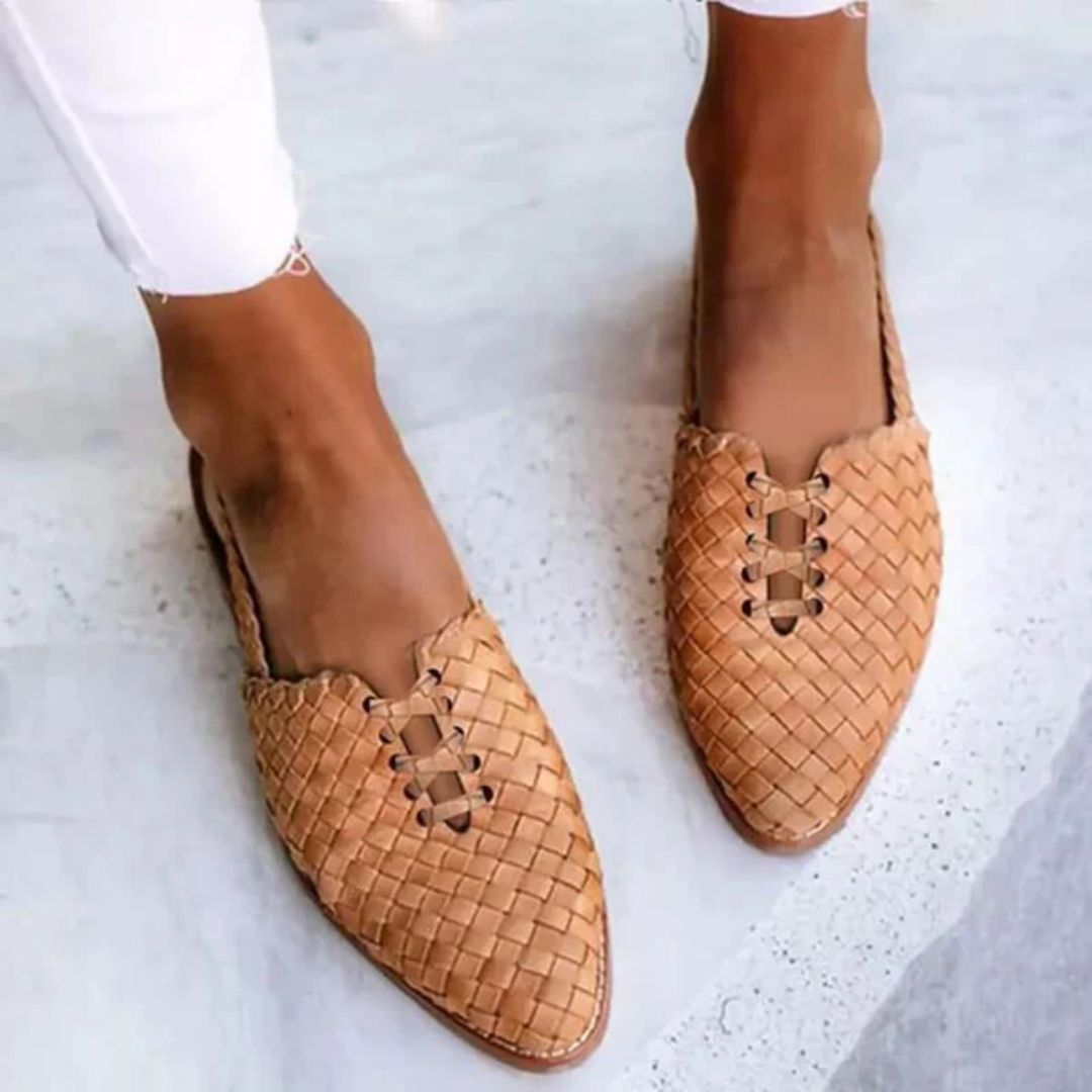 Brown woven slip-on sandals worn outdoors on feet