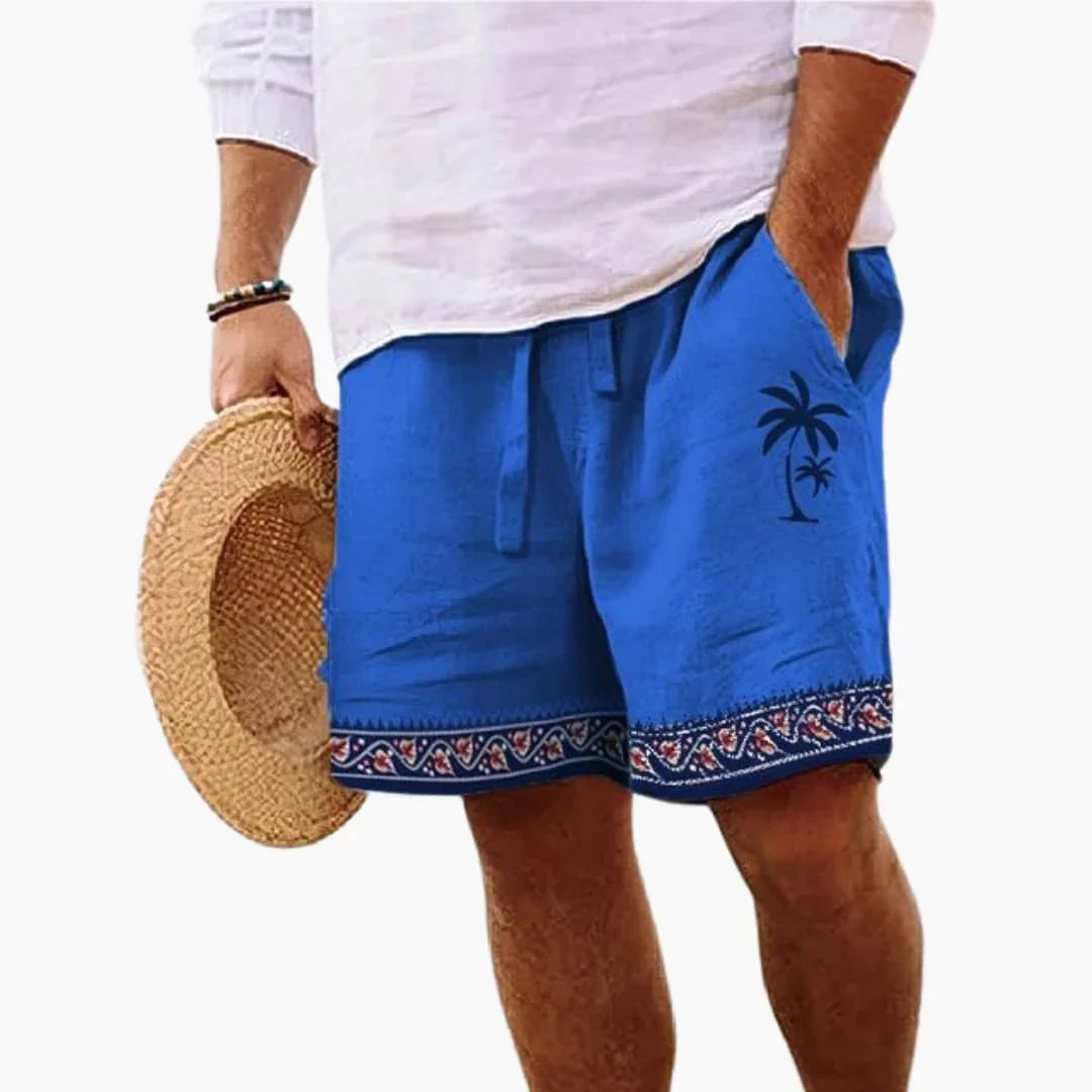 Man wearing dark blue drawstring swimming shorts with palm tree design