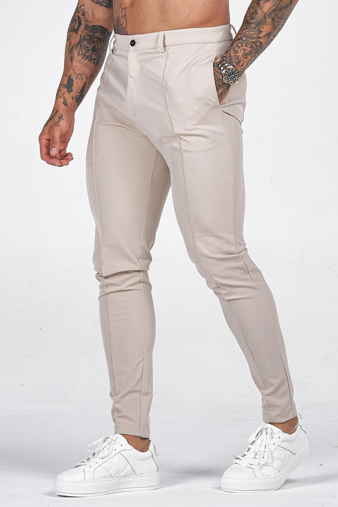 Man wearing beige slim fit dress trousers with white sneakers