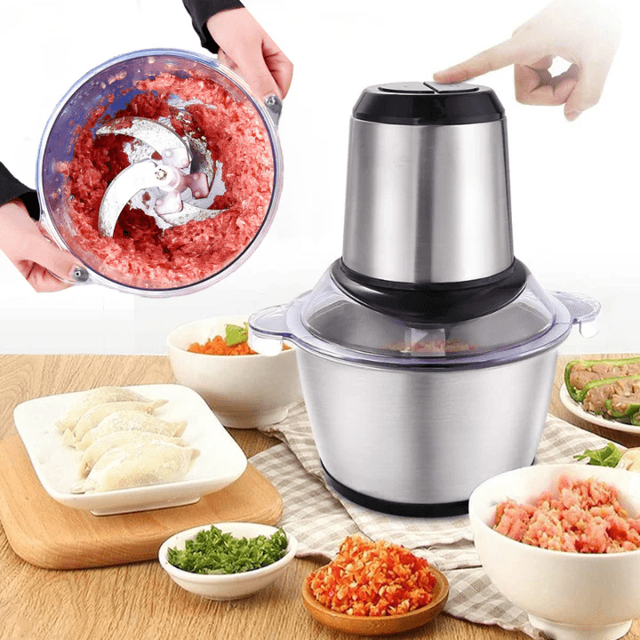 Electric kitchen grinder processing meat with bowls of chopped ingredients nearby