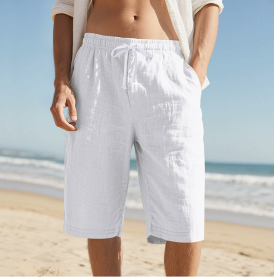 Man wearing white knee length casual pull on shorts at the beach