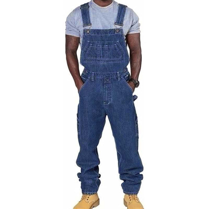 Front view of a man wearing relaxed fit denim work overalls with chest and side pockets