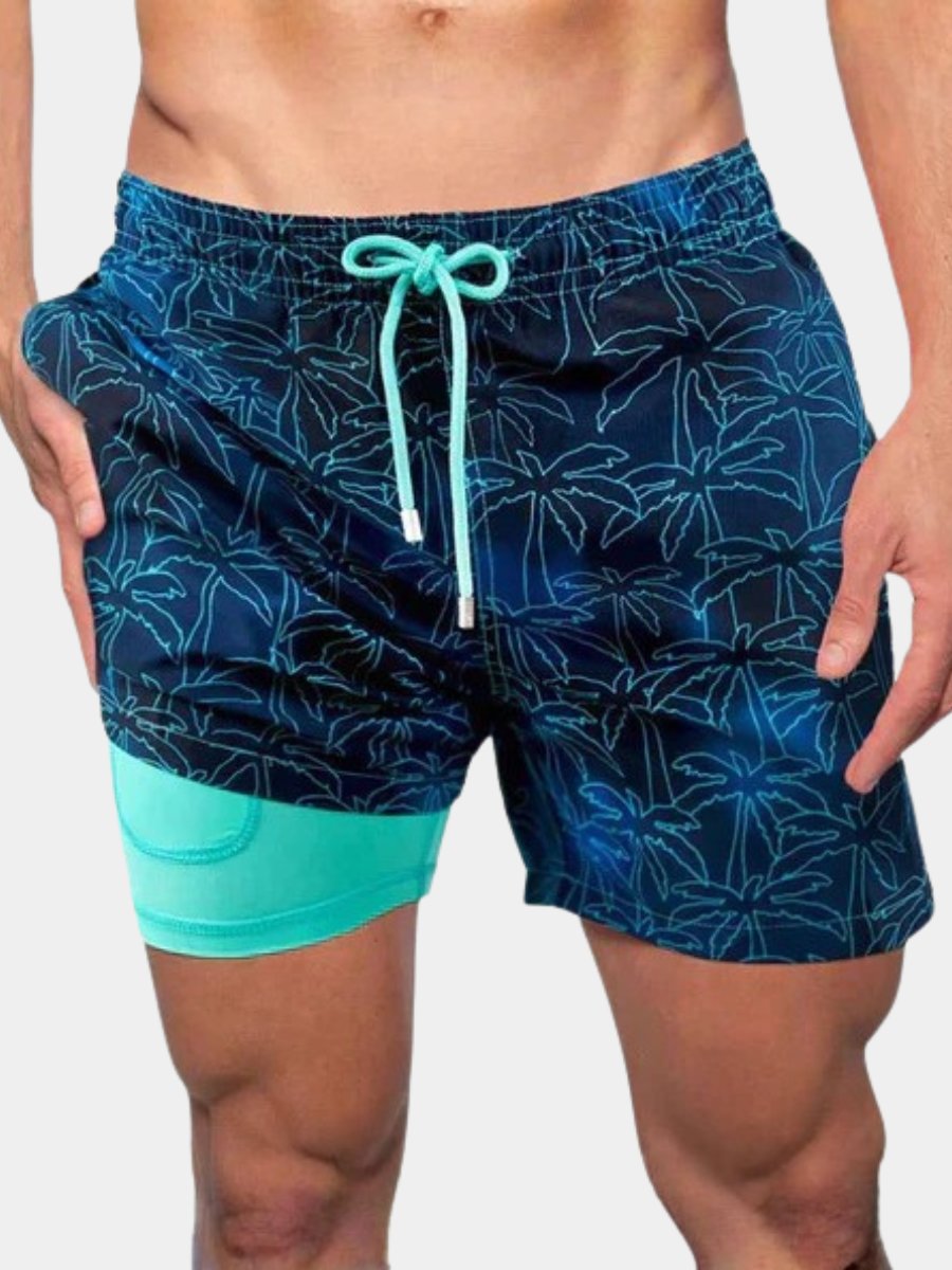 Men's navy blue quick-dry swim shorts with tropical print and turquoise compression liner