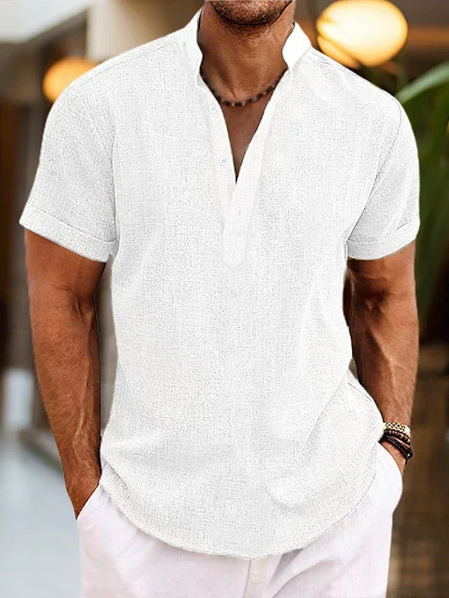 Man wearing a white short sleeve Henley shirt with white trousers