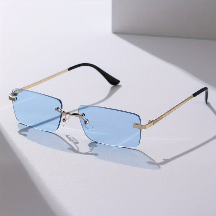Blue glass frameless sunglasses with gold metal arms on a sleek surface