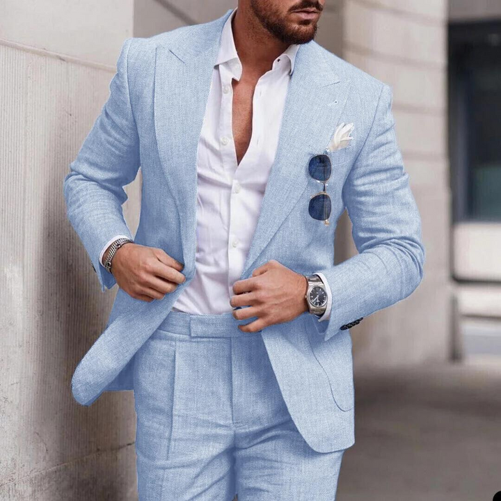 Man wearing a light blue two-piece suit for a beach wedding with a white shirt and sunglasses