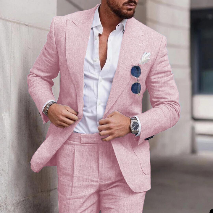 Man wearing a light pink two-piece suit with a white shirt and silver wristwatch