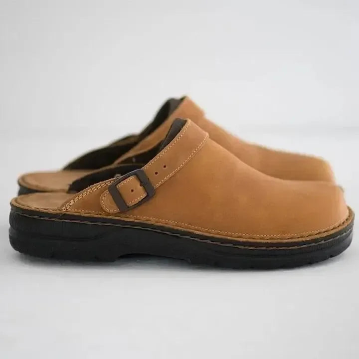Studio shot of men's slip-on comfort clogs in beige with adjustable buckle strap