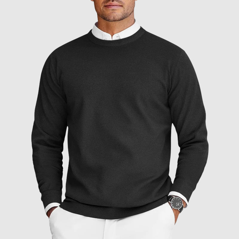 Man wearing black men's knit sweater with layered white shirt