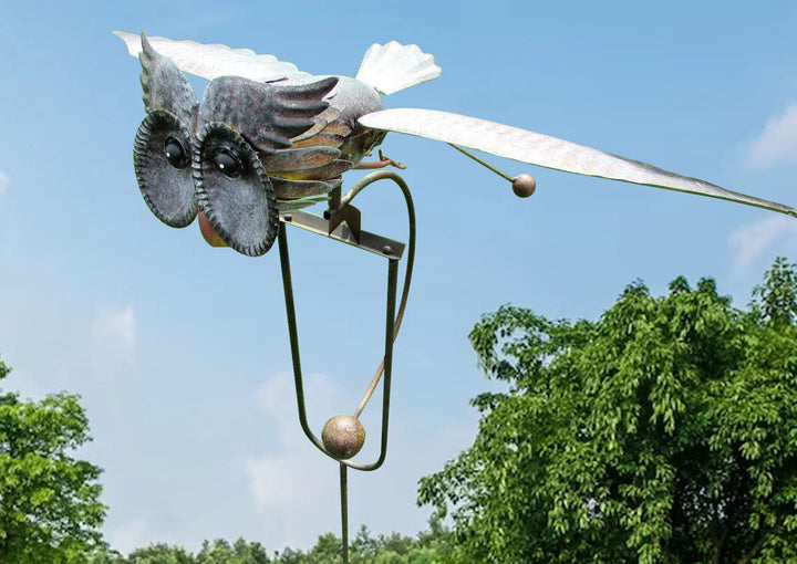 Detailed view of the standing owl metal garden wind spinner against a blue sky