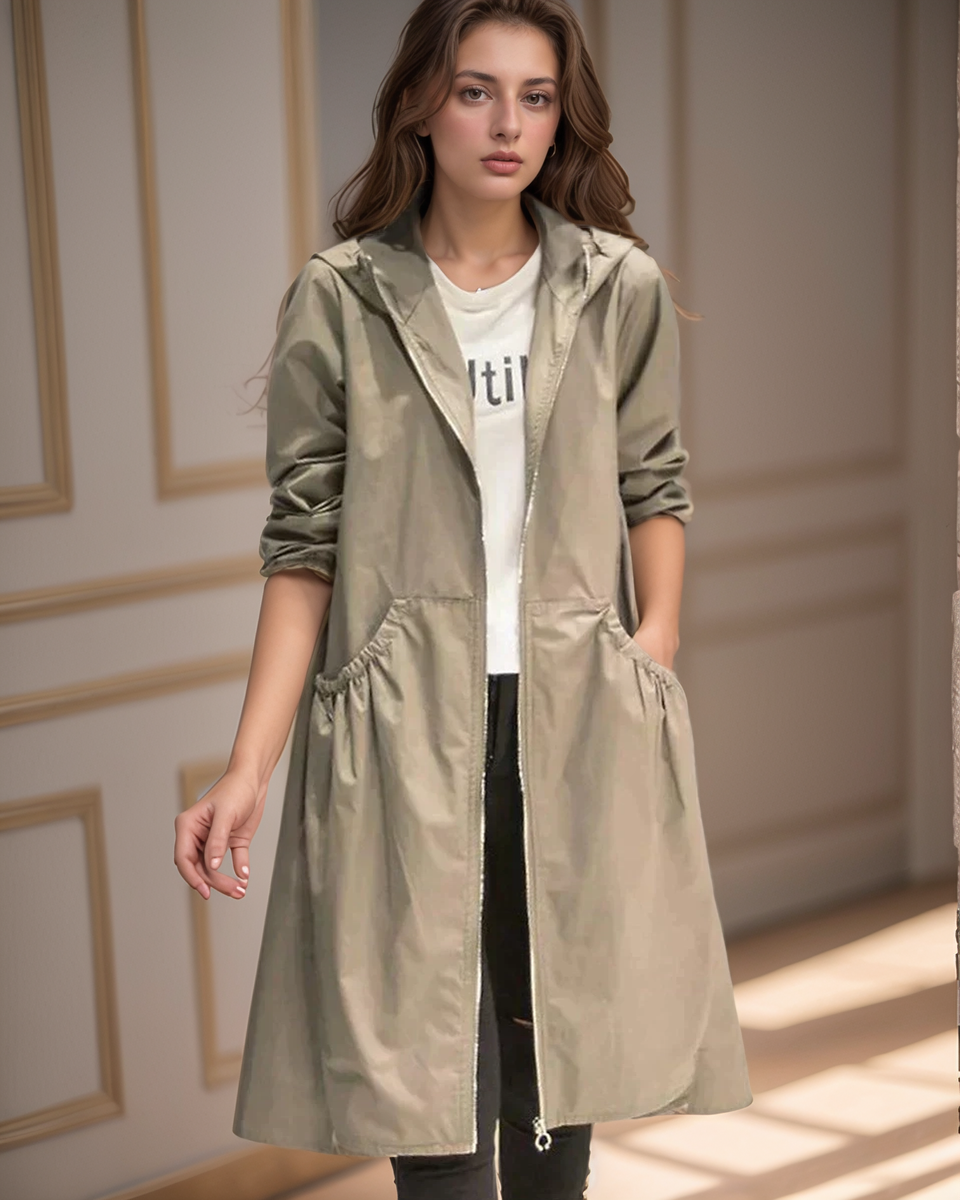 Woman wearing a beige longline hooded jacket with front pockets in an interior setting
