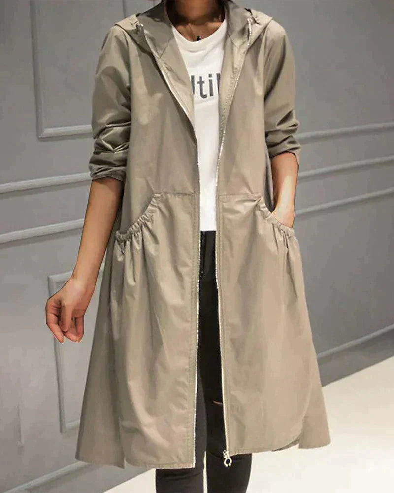 Close-up view of the beige longline hooded jacket showing zipper and pocket details
