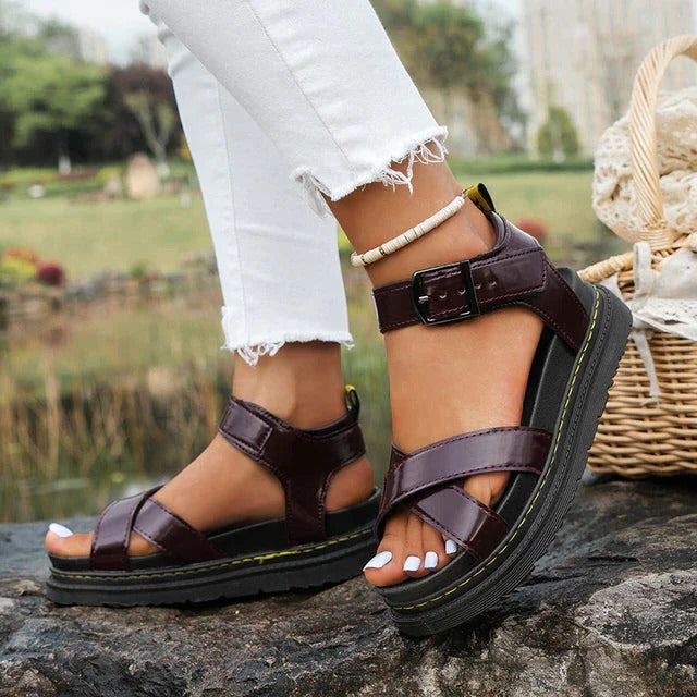 Close-up of women's burgundy chunky platform sandals worn outdoors