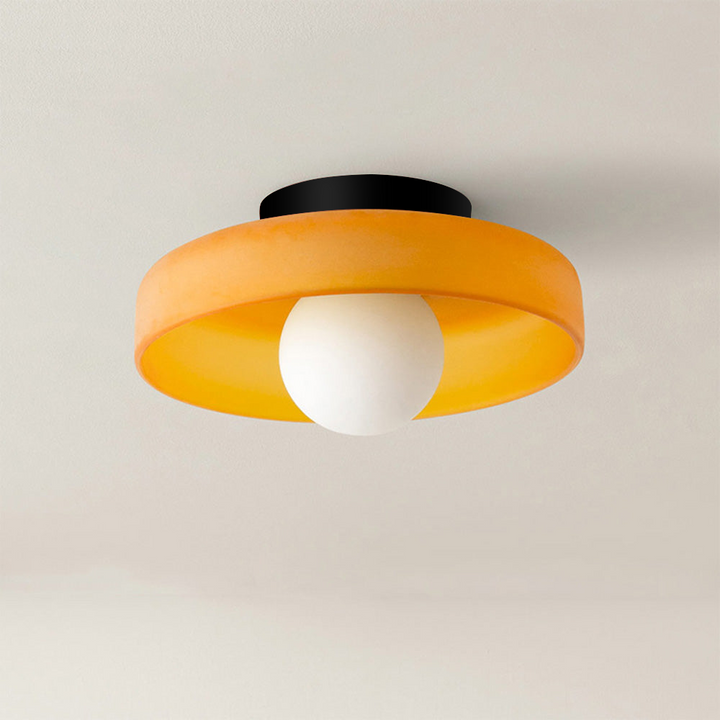 Vibrant orange minimal flush mount ceiling light fixture against a neutral background