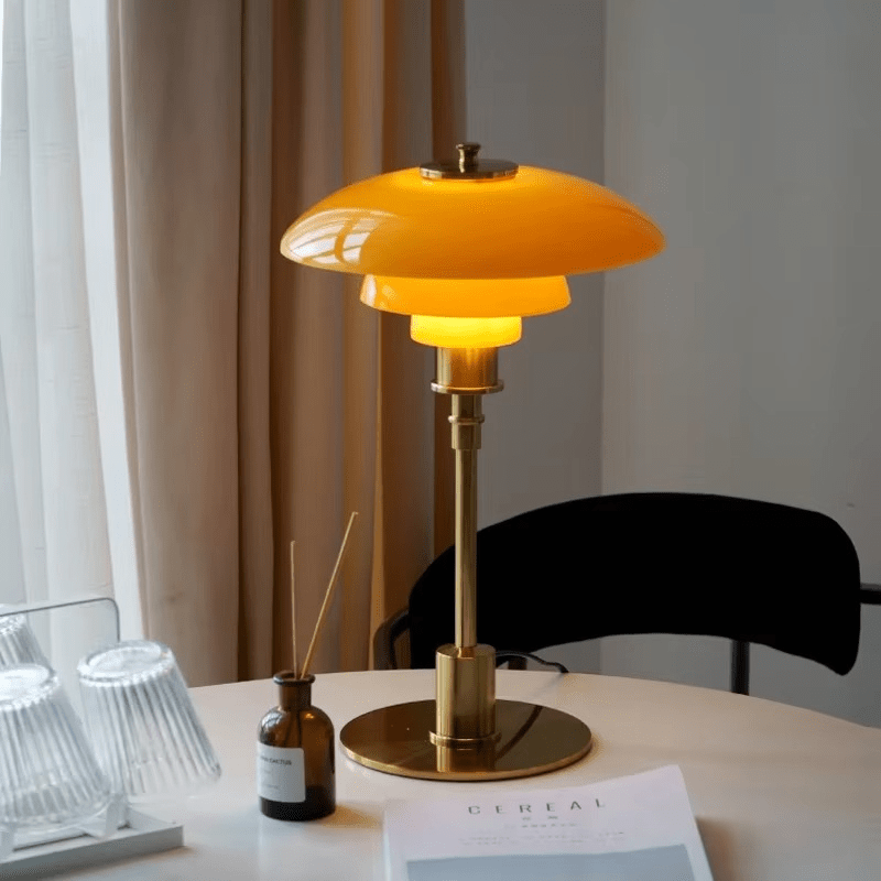 Amber gold table lamp glowing softly on a dining table next to decor