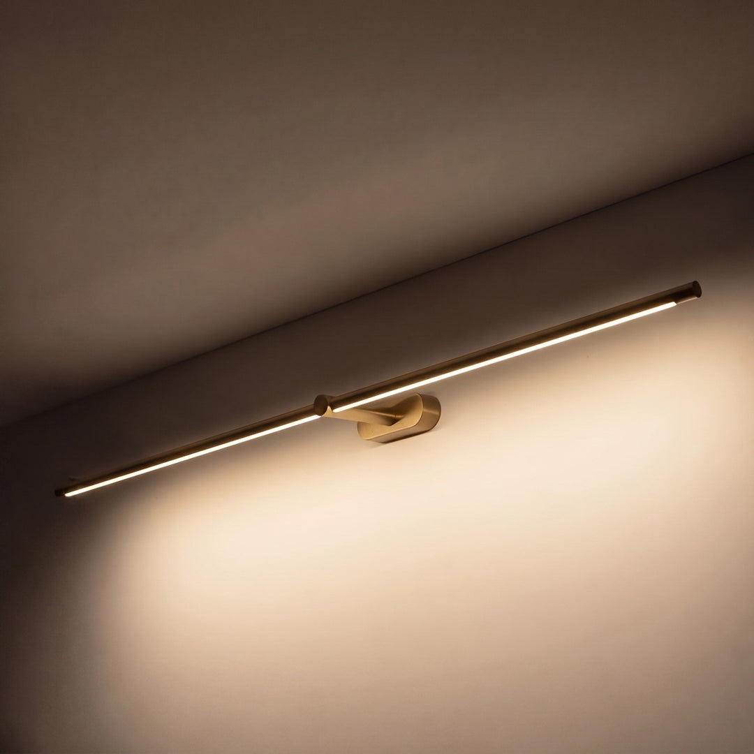 Minimalist gold LED wall sconce mounted horizontally on a neutral wall