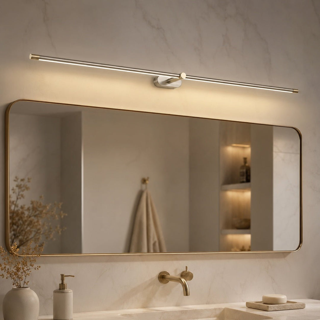 Brushed nickel and gold LED wall light fixture illuminating a contemporary bathroom