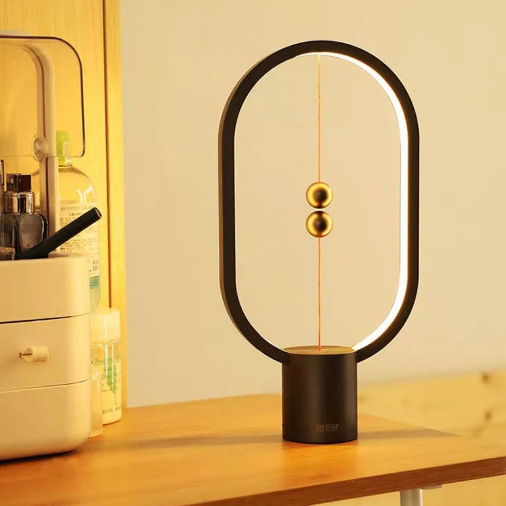 Modern balance table lamp casting a soft glow, ideal for workspaces and reading areas.