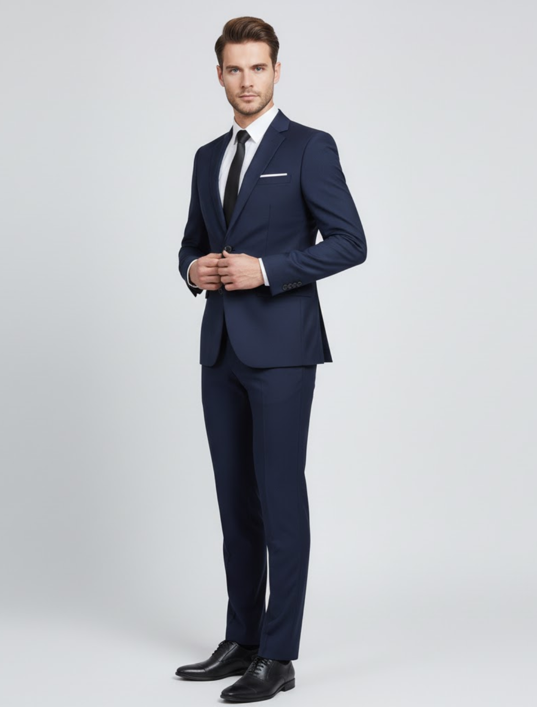 Man wearing a navy blue modern fit two-piece suit with white shirt and black tie