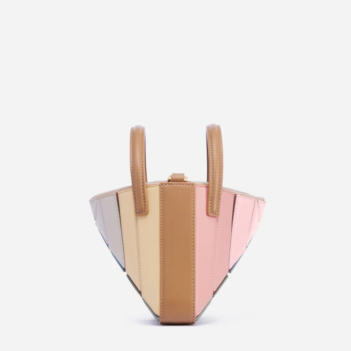 Model carrying the modern geometric handbag as a stylish shoulder bag