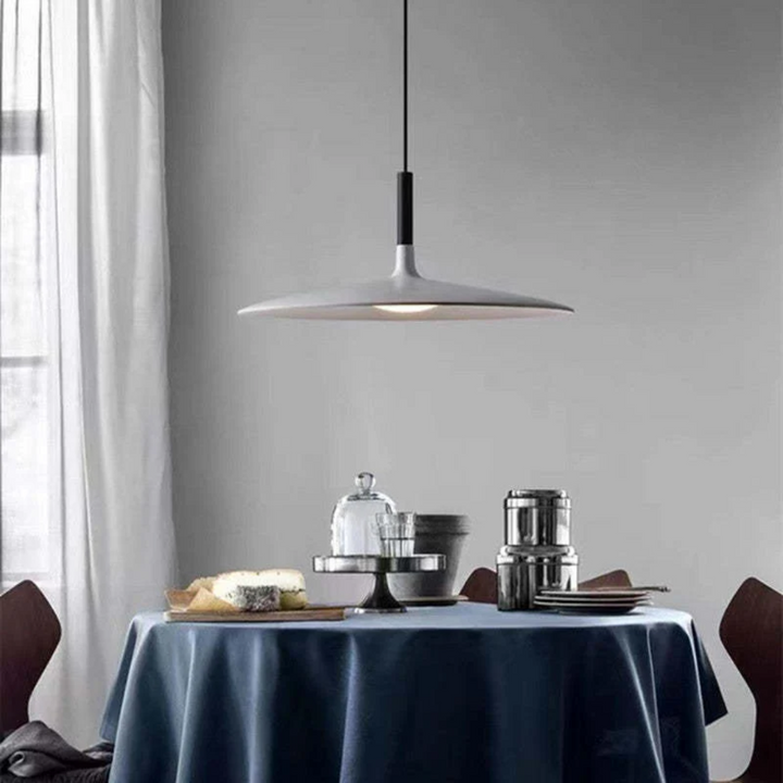 Close-up of the sleek minimalist LED ceiling lamp emitting warm interior design lighting.