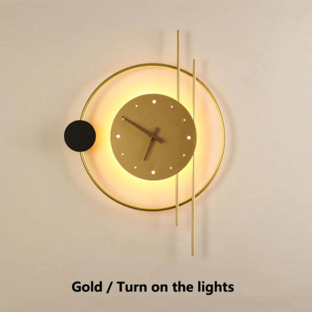 Close-up of the gold Chronos LED wall clock lamp illuminated against a wall.