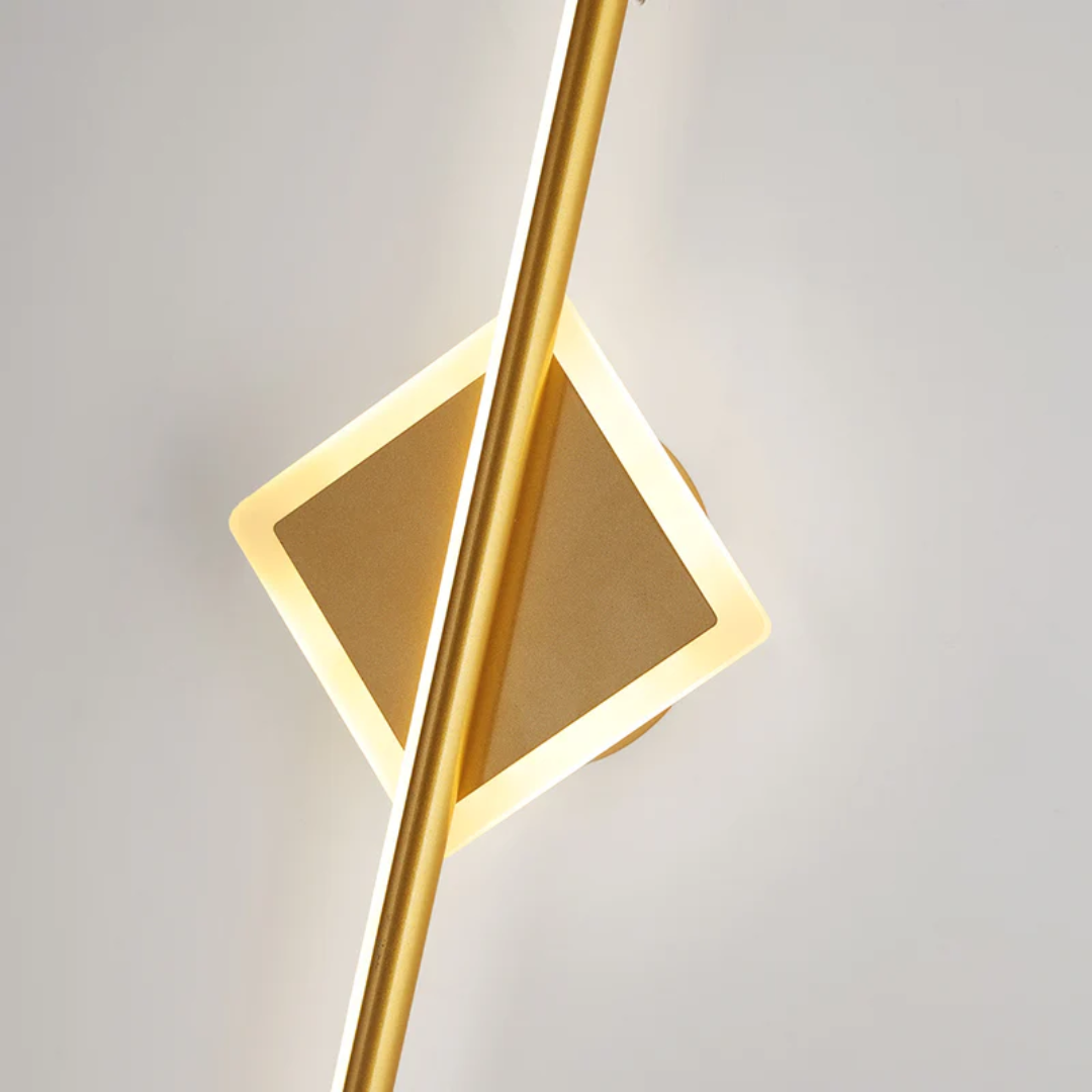 Modern square gold LED wall lamp mounted on a light wall