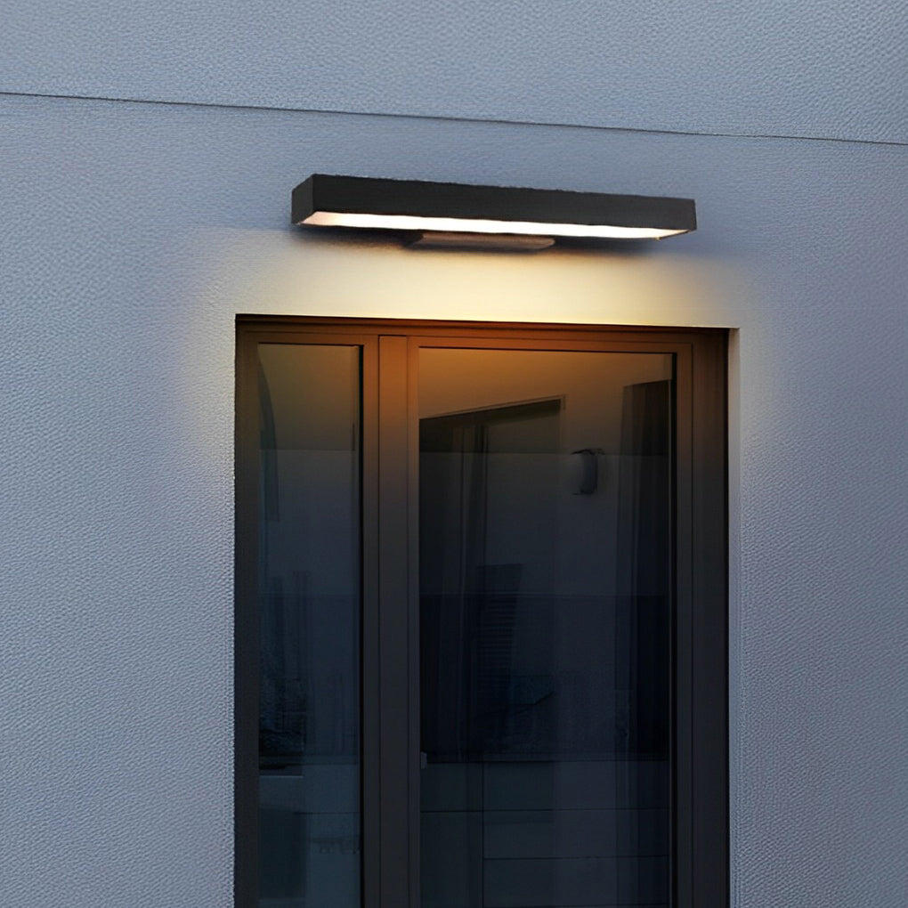 Modern black LED wall lamp mounted beside a glass door at dusk